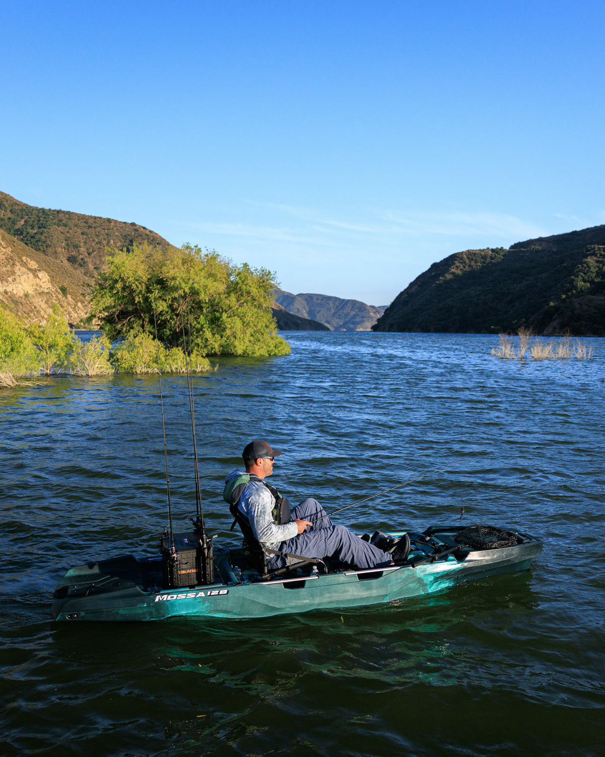 Angler fishing from a MOSSA 128 kayak on a lake — genuine manufacturer photo